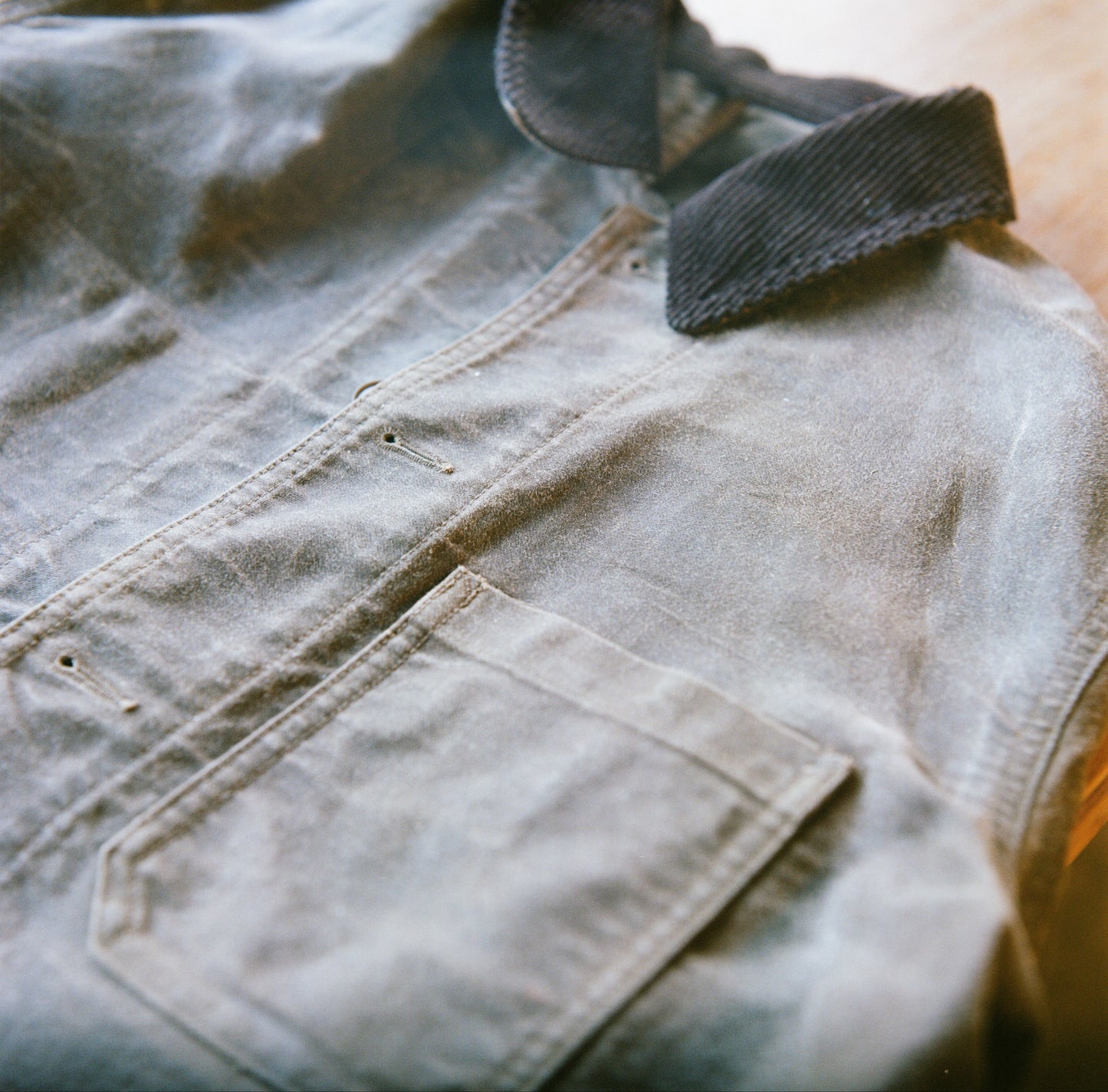 Close-up of a brown Muji chore coat with a corduroy collar after canvas waxing.