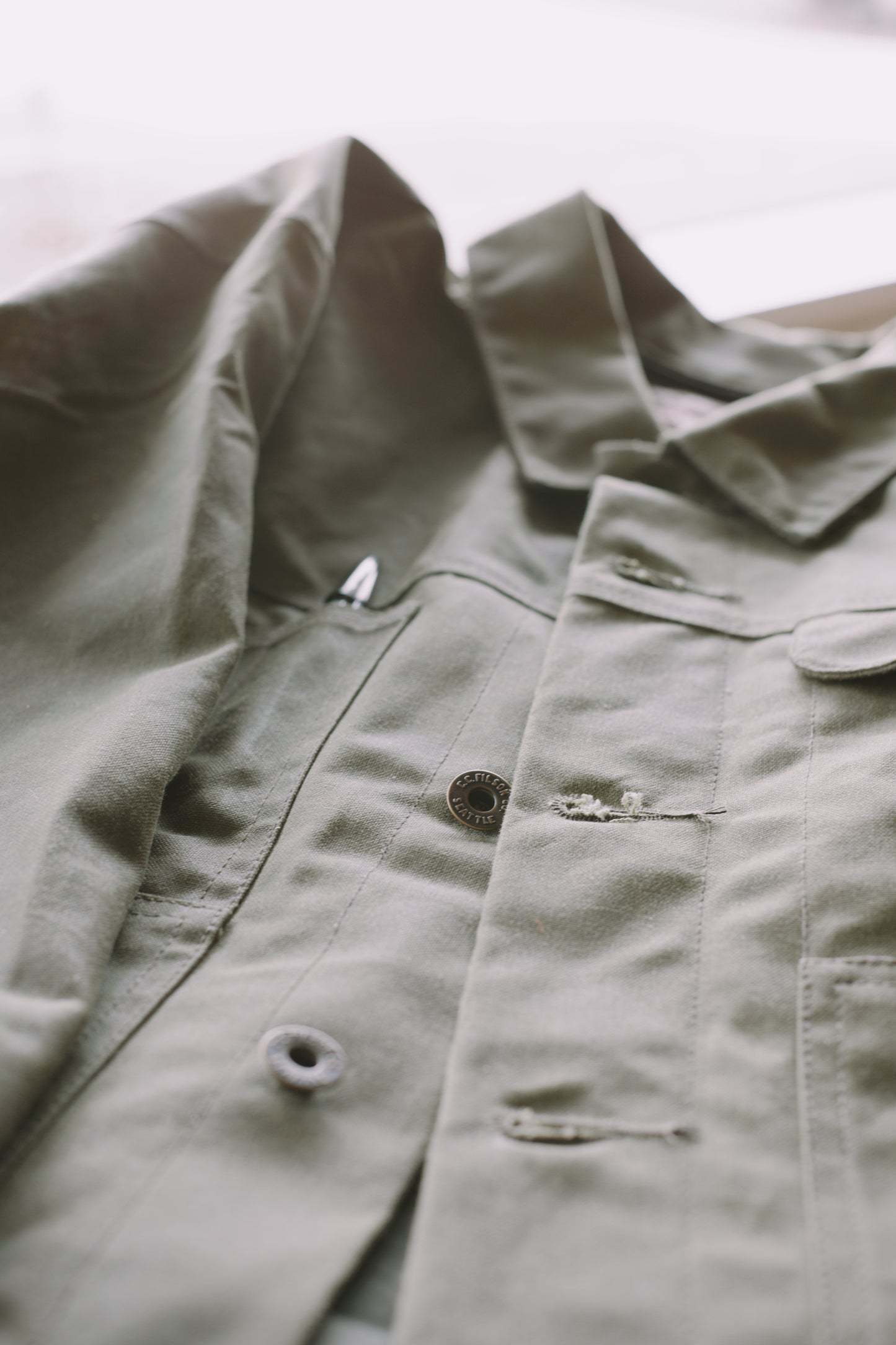 An image of a Filson SLC Short Lined Cruiser in military green .