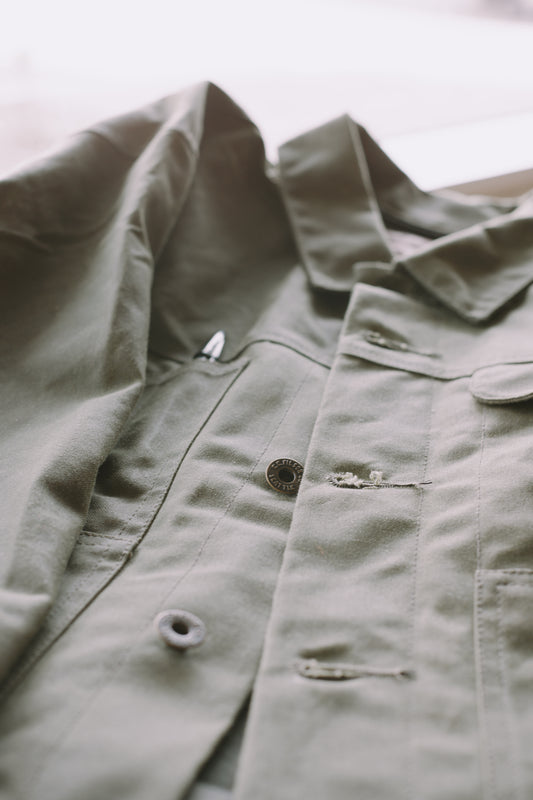 An image of a Filson SLC Short Lined Cruiser in military green .