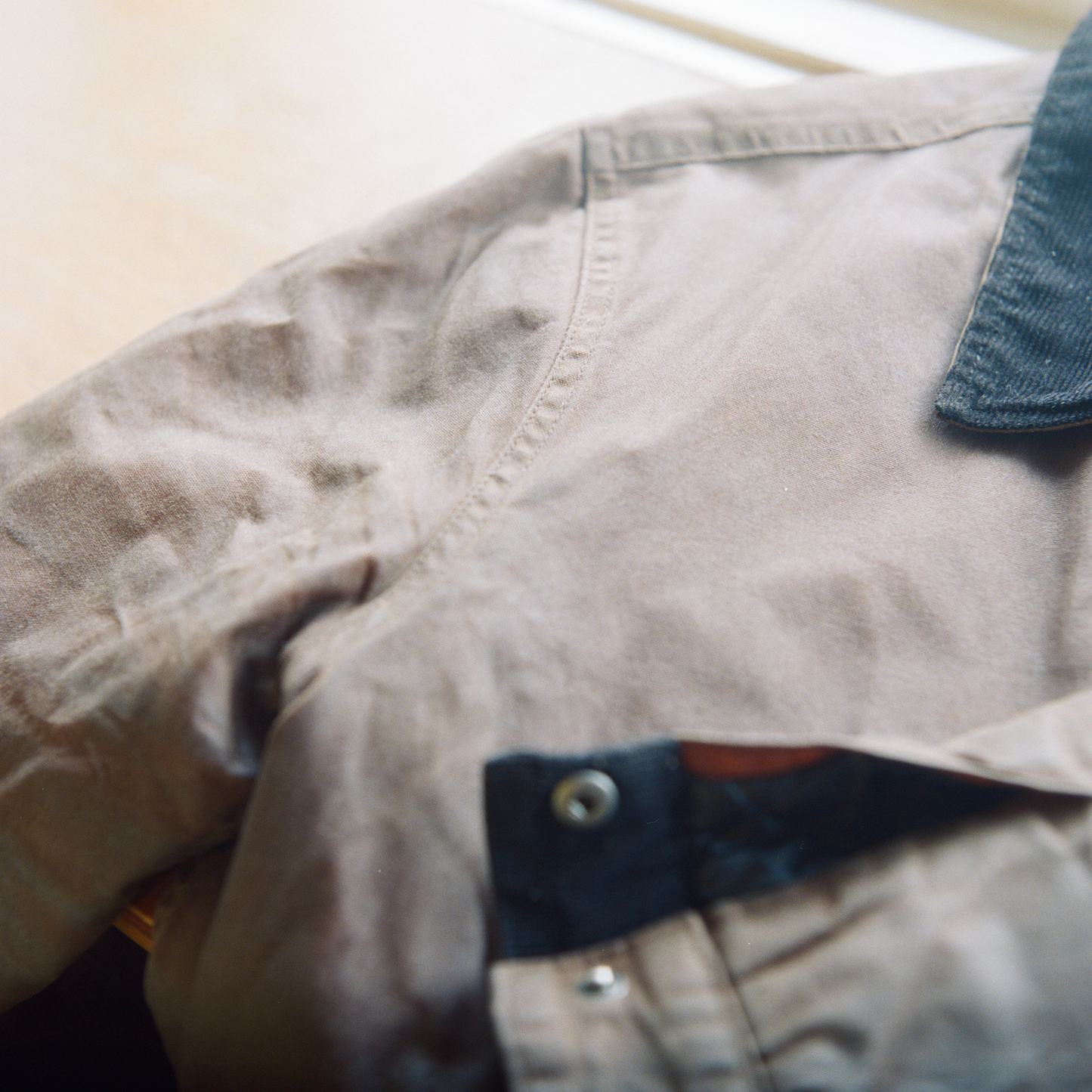 Close up of a brown waxed canvas Flint and Tinder trucker jacket with a corduroy collar.