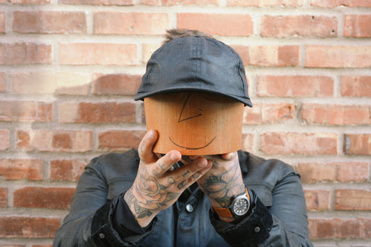 An image of a person holding a waxed canvas hat.